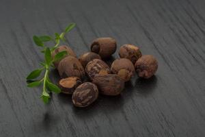 Small nutmeg on wooden background photo