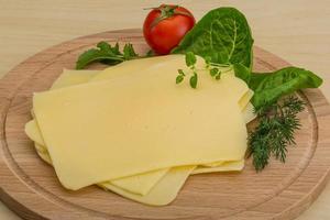 Sliced cheese on wooden board photo