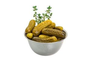 Marinated cucumbers in a bowl on white background photo