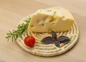 Maasdam cheese on wooden background photo