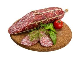 salami en placa de madera y fondo blanco. foto