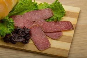 Salami sausages on wooden plate photo