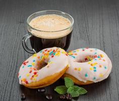 café con donuts sobre fondo de madera foto