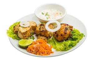 Chicken Tikka on the plate and white background photo