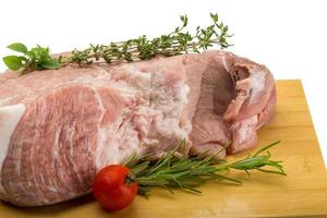 Raw pork meat on wooden plate and white background photo