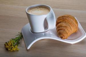 Coffee with croissant on the board photo