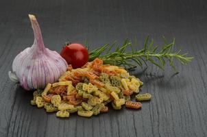 Colored pasta on wooden background photo