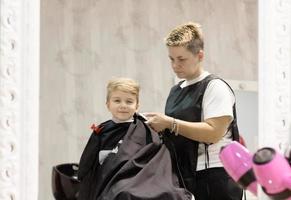 reflejo en un espejo de un niño durante el corte de pelo en la peluquería. foto
