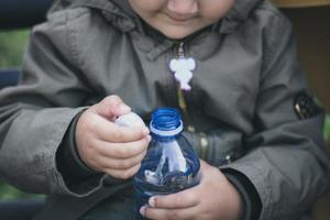 Close up of kid opening bottle of water. photo