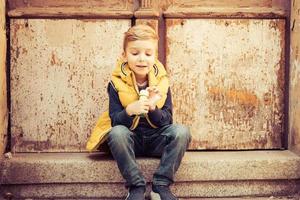 Cute boy relaxing on steps outdoors. photo