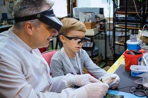 IT teacher and small boy examining computer part. photo