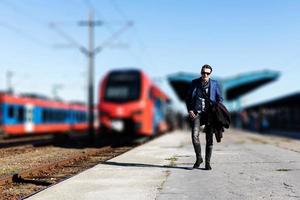 longitud completa de un hombre de negocios en la plataforma de la estación de ferrocarril. foto