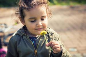 Cute girl smelling flower with eyes closed. photo