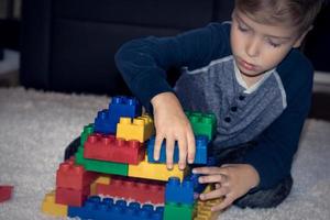 Small boy playing with toy blocks. photo