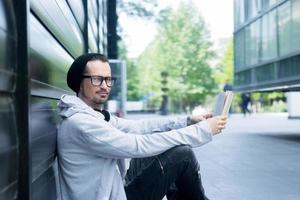 Smiling man reading book in front of library. photo