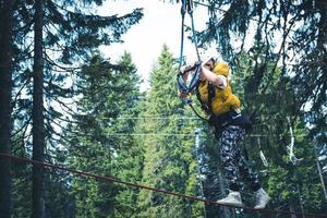 Small boy on rope course in the forest. photo