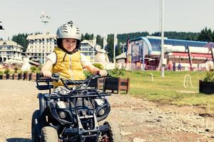 niño pequeño en un quad en la naturaleza. foto