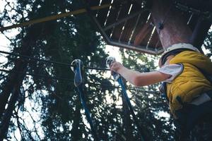 Below view of kid on rope course in nature. photo