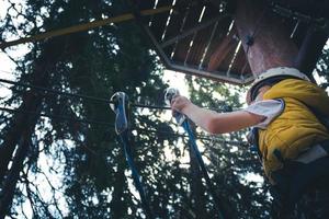 Below view of kid on rope course in nature. photo