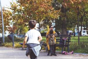 Rear view of kids running in mother's embrace. photo