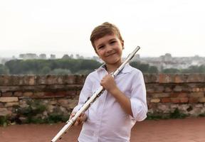 retrato de un pequeño músico feliz con una flauta. foto