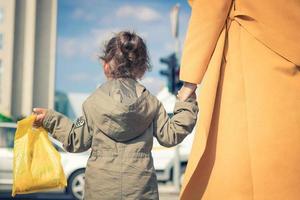 Back view of small girl holding mother's hand. photo