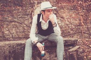 Pensive man with beer bottle thinking outdoors. photo