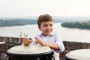 Smiling kid tapping the bongos. photo