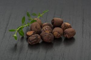 Small nutmeg on wooden background photo