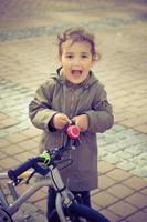 niña usando campana de bicicleta y gritando. foto