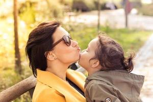 niña pequeña besando a su madre. foto