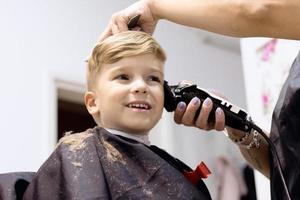 Cute kid at hairdressers. photo