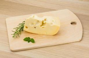 Maasdam cheese on wooden background photo