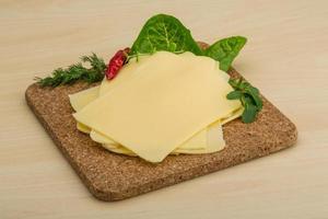 Sliced cheese on wooden board photo