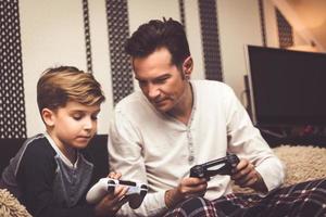 Small boy explaining to his father how to use game controller. photo