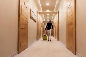 Man with travel bag walking through a hallway. photo