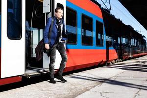 longitud total del hombre de negocios saliendo de un tren en la estación. foto