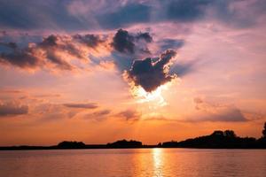 Scenics sunset behind clouds above the lake. photo