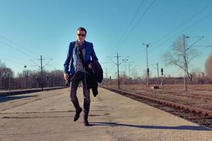 Full length of man walking at railroad station platform. photo