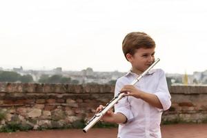Happy kid playing flute. photo