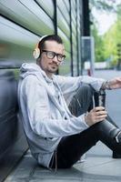 trabajador independiente tomando café y escuchando música con auriculares. foto