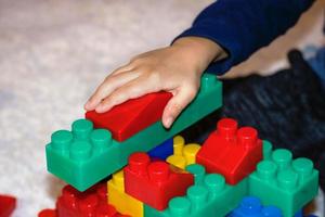 Close up of child playing with toy blocks. photo