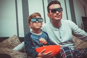 padre e hijo viendo películas con anteojos 3d. foto