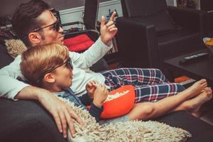 padre e hijo viendo películas en 3d por la noche. foto