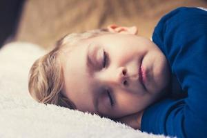 lindo niño durmiendo en la cama. foto