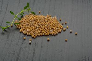 Mustard seeds on wooden background photo