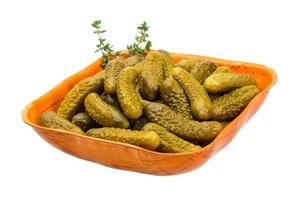 Marinated cucumbers in a bowl on white background photo