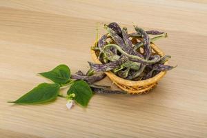 Beans with leaf in a basket on wooden background photo