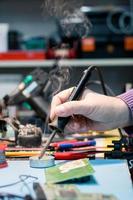 Close up of man soldering computer component. photo