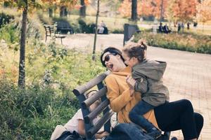 Playful kids and their mother having fun in the park. photo